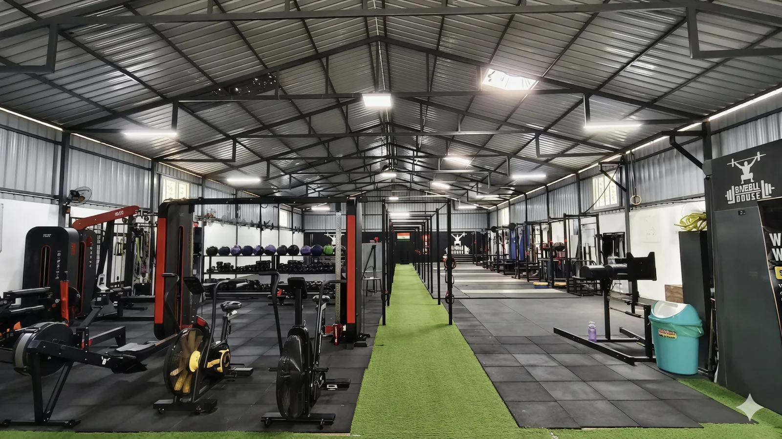 Wide view of the Barbellhouse main hall, green astroturf strip down the centre